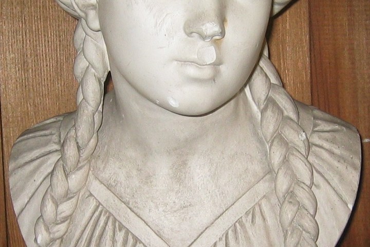 Borstbeeld van een meisje met vlechten en tulband