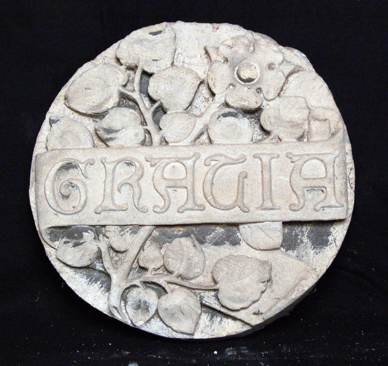 Cirkelvormige platte steen met de tekst 'GRACIA' in banderole