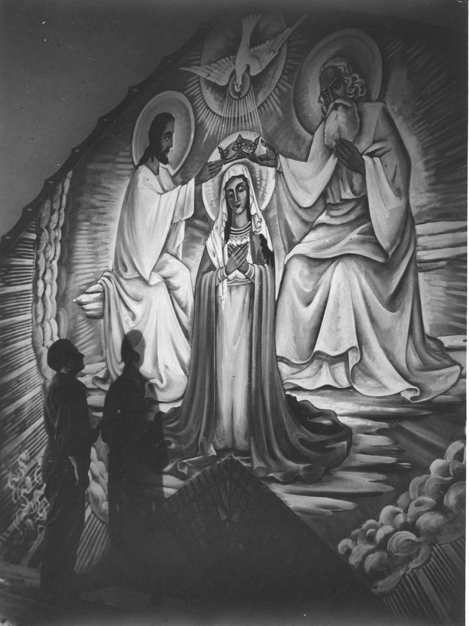 Foto van een wandschildering in de kerk van Mariahoop met de schilder erbij.