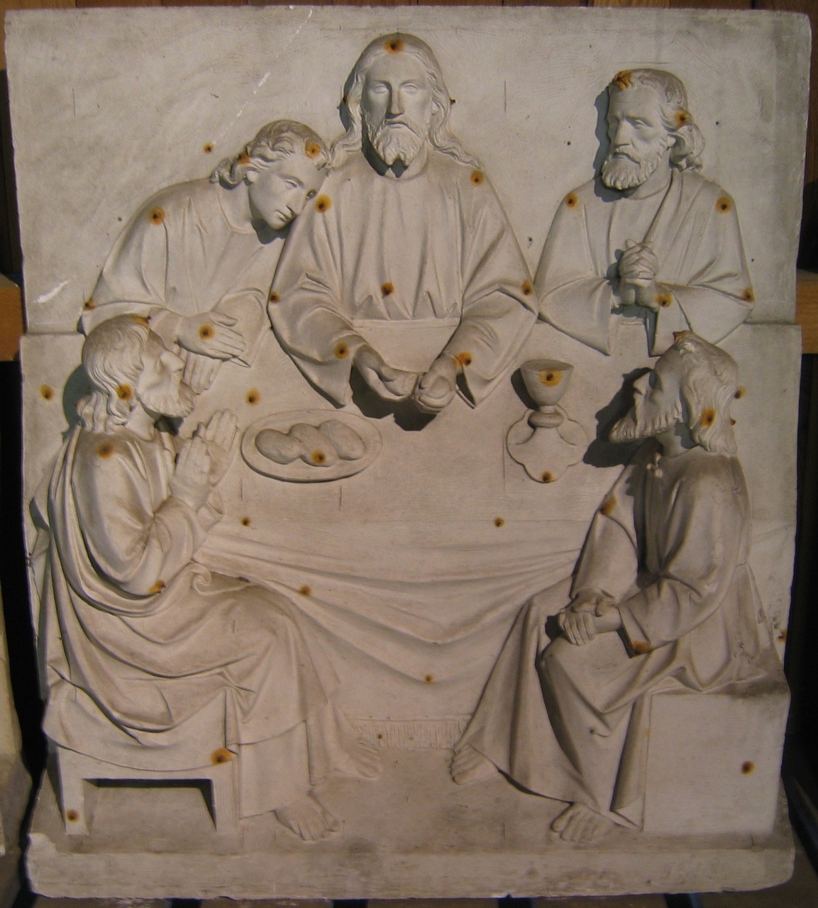 Staand gipsreliëf waarop Christus brood uitdeelt aan vier discipelen (Laatste Avondmaal?)