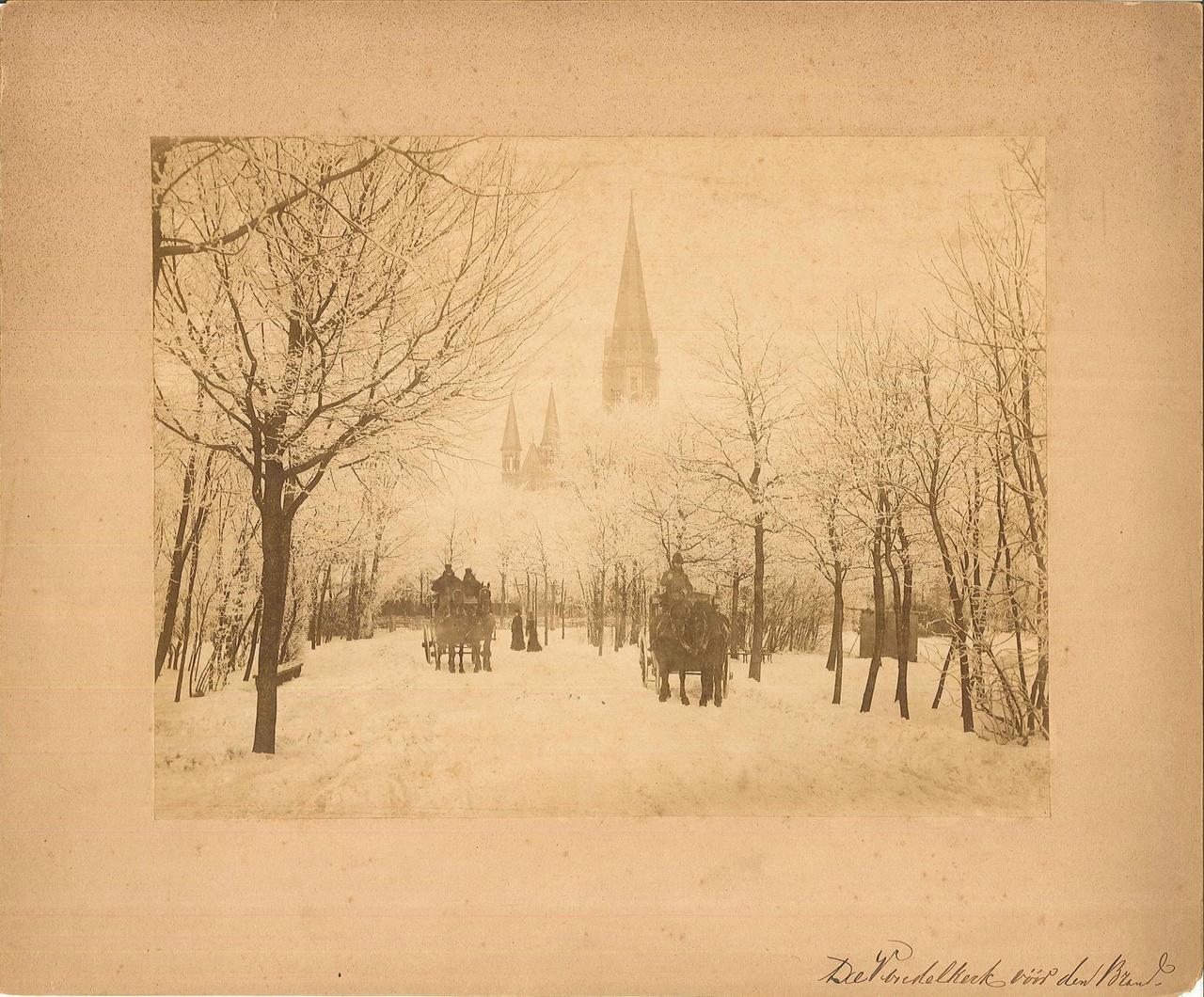 Foto van het Vondelpark en de Vondelkerk te Amsterdam in een sneeuwrijke omgeving.