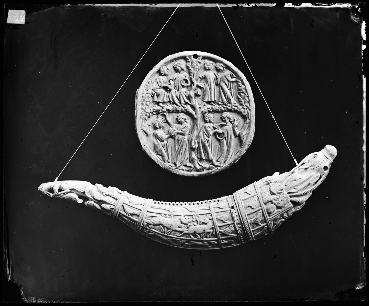 Glasnegatief van foto van producten uit de Cuypers' Kunstwerkplaatsen: Een kruithoorn en een medaillon