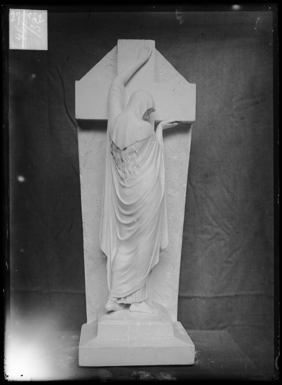 Glasnegatief van foto van producten uit de Cuypers' Kunstwerkplaatsen: "Foto van een beeld van een vrouw die met beide armen een kruis omarmt".