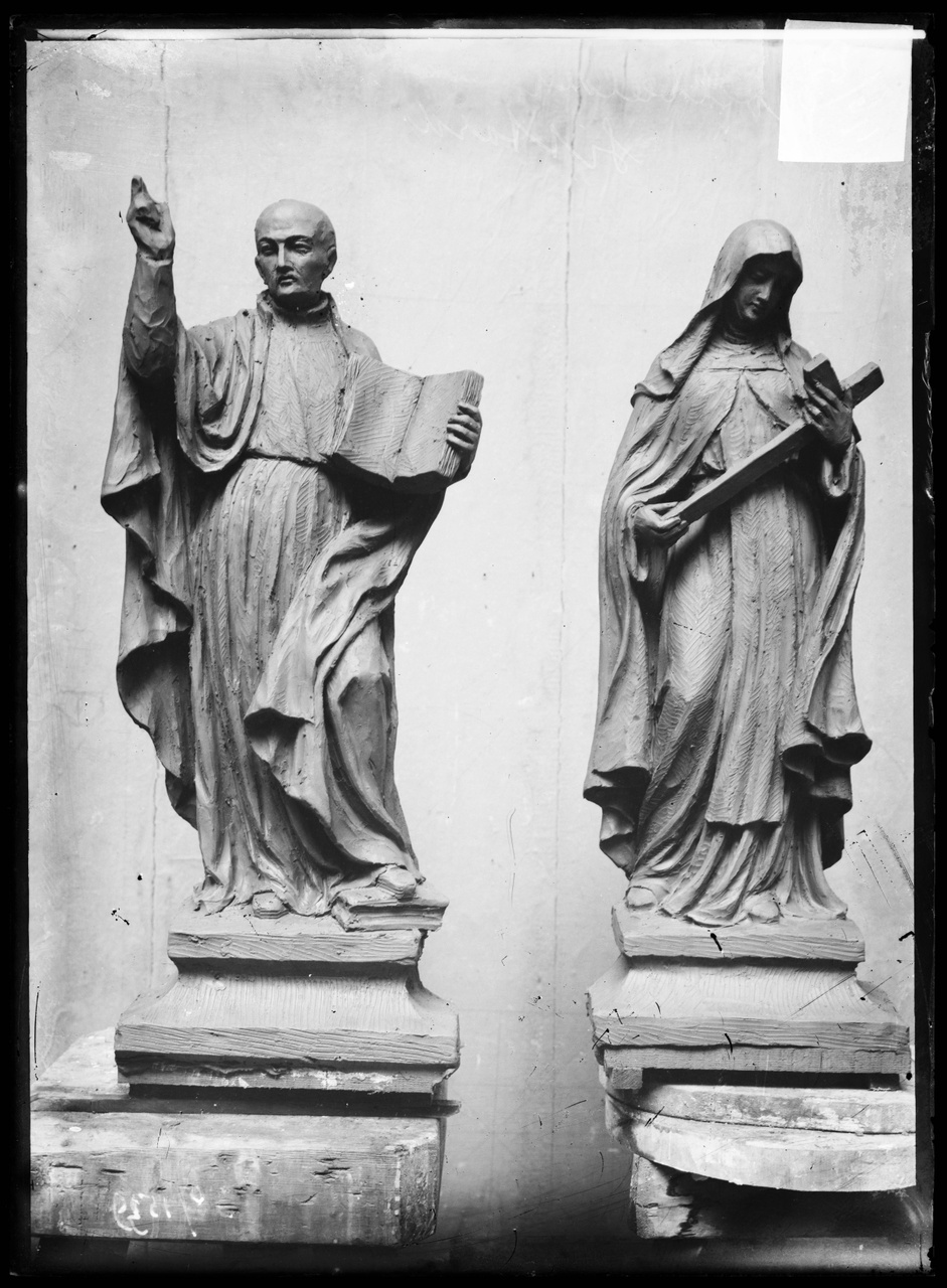 Glasnegatief van foto van producten uit de Cuypers' Kunstwerkplaatsen: "Foto van twee beelden: van een priester met boek en van een vrouw met crucifix".