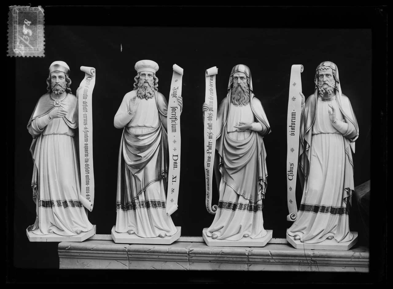 Glasnegatief van foto van producten uit de Cuypers' Kunstwerkplaatsen: "Foto van vier beelden van mannelijke heiligen met banderoles.".