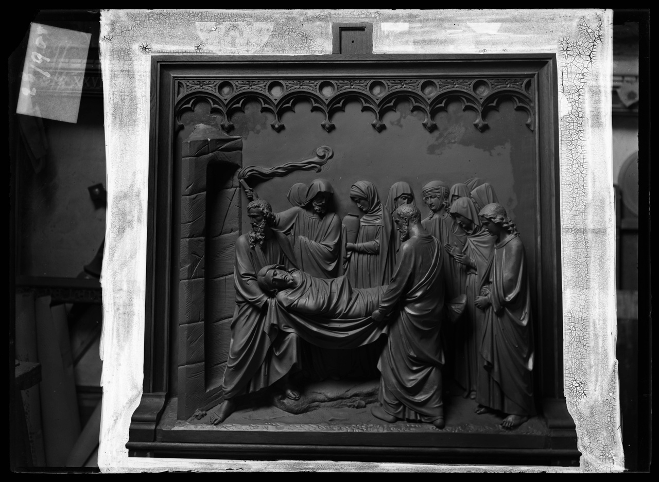 Glasnegatief van foto van producten uit de Cuypers' Kunstwerkplaatsen: "Foto van een houten sierlijst met daarin een reliëf van een kruiswegstatie: de graflegging van Christus".