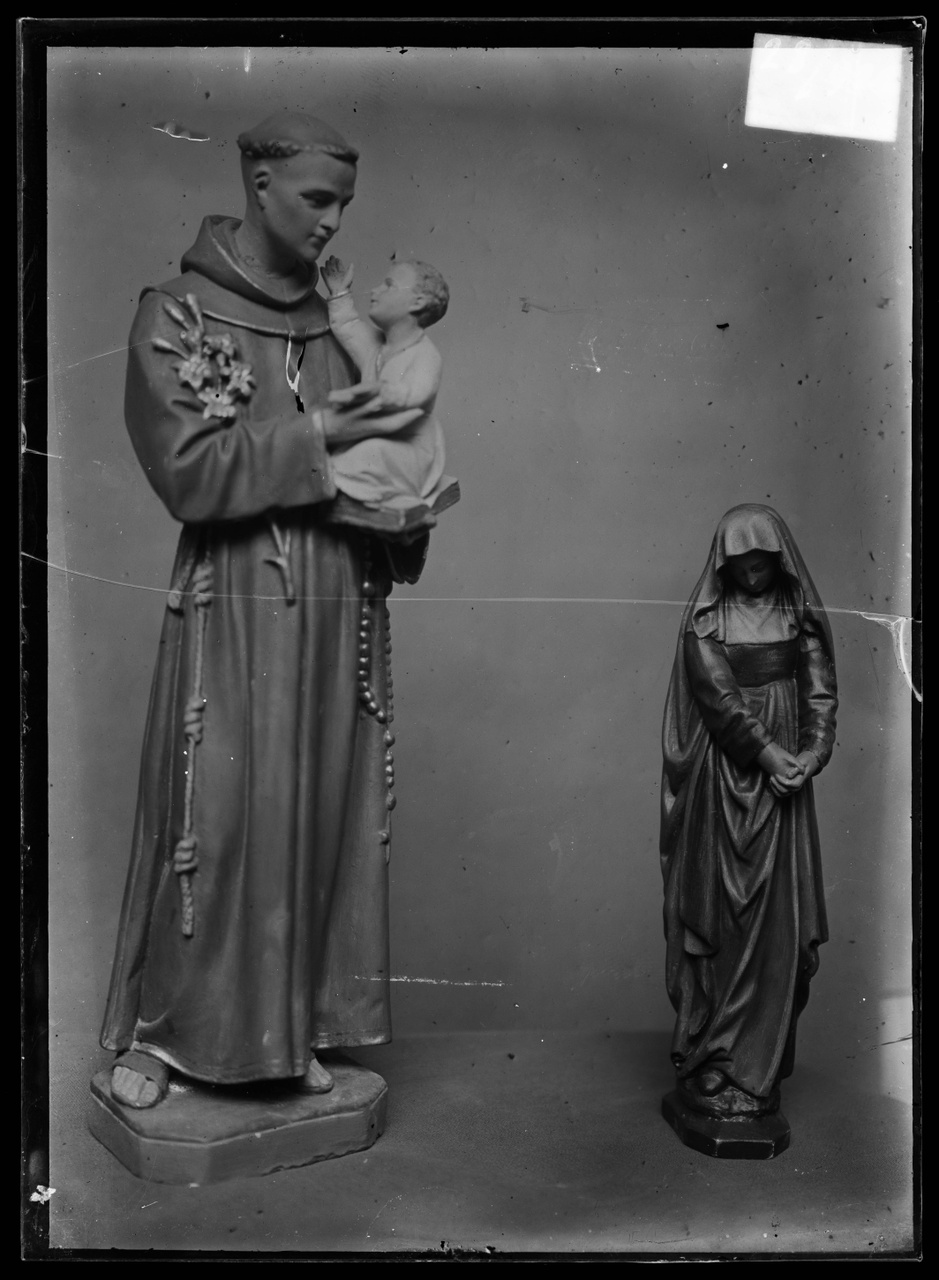 Glasnegatief van foto van producten uit de Cuypers' Kunstwerkplaatsen: "Foto van twee beelden: een monnik met Christuskind in de armen en een kleiner beeld van een vrouw".