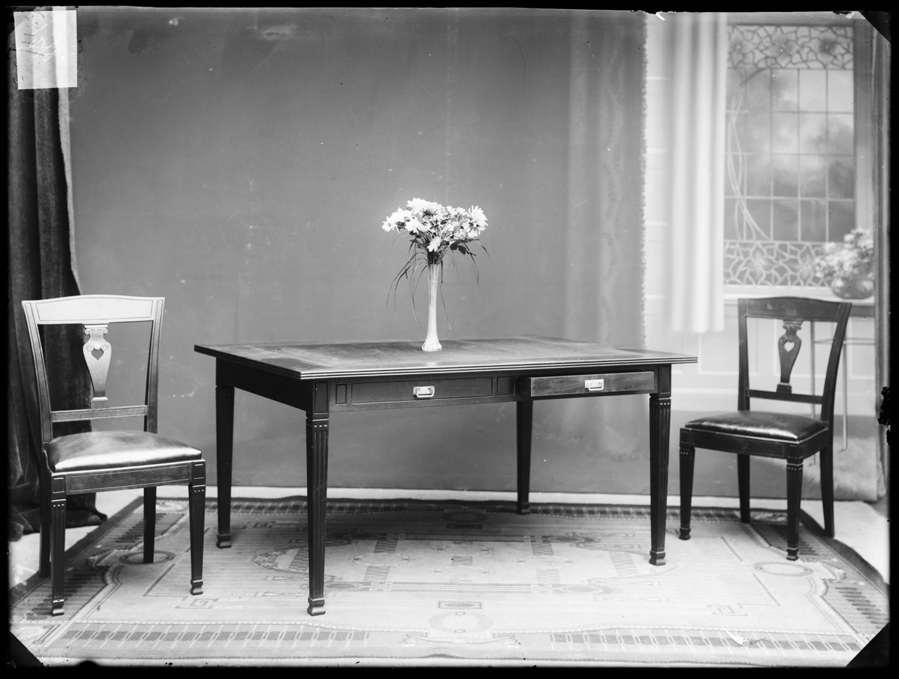 Glasnegatief van foto van producten uit de Cuypers' Kunstwerkplaatsen: "Foto van een tafel en twee stoelen".