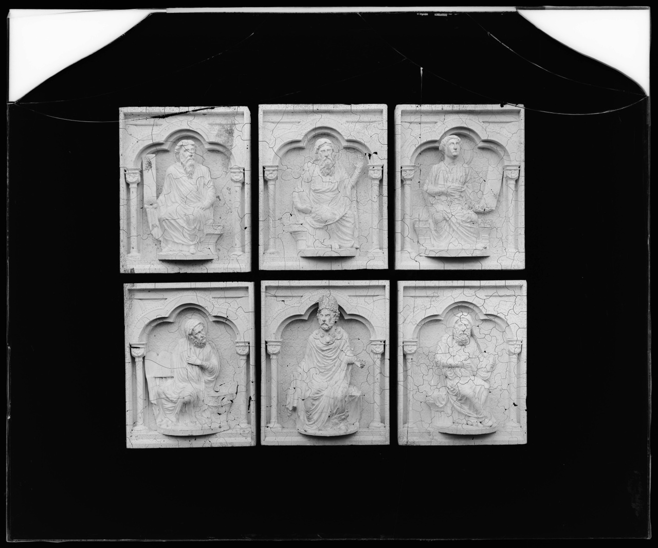 Glasnegatief van foto van producten uit de Cuypers' Kunstwerkplaatsen: "Foto van zes paneeltjes met voorstellingen van zittende mannen, waaronder een bisschop".