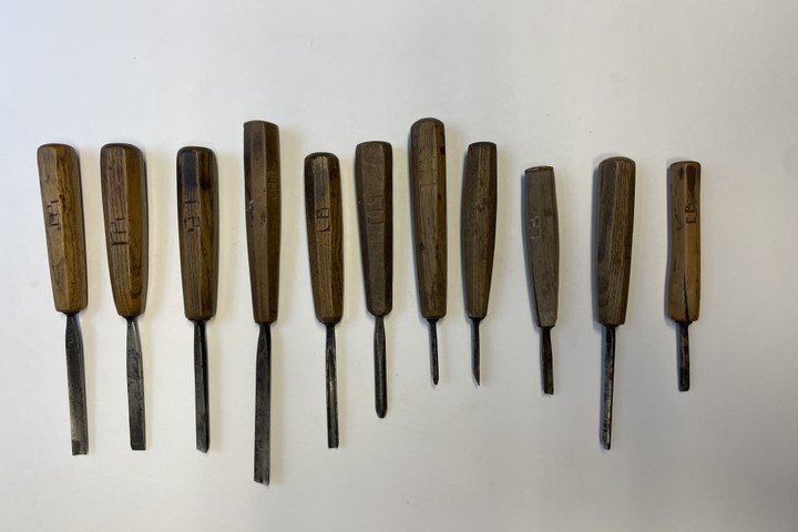 Elf gutsen en beitels met houten handvat.